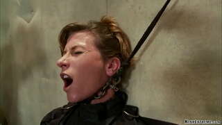 Strapped brunette MILF slave Ariel X is pinned on illuminating table then chained gets anal fucked with dildo on a stick in hands of master Orlando